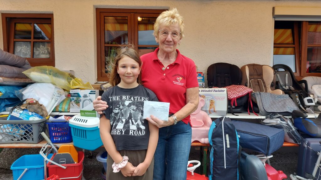 Laura überreicht ihr Kommunionsgeld als Spende für die Kinderkrebshilfe BGL+TS