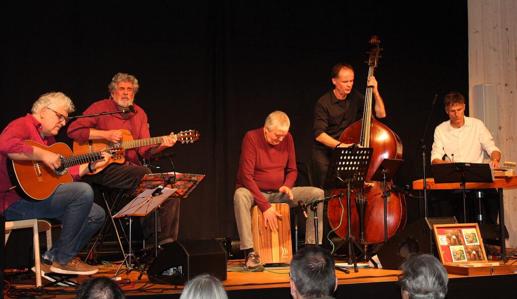 Auf dem Foto sieht man das Trio SurMonte und das Duo Carovana Mediterranea auf der Bühne des Festsaals im Kulturhof Stanggaß, während ihres Benefizkonzerts für die Kinderkrebshilfe BGL+TS.