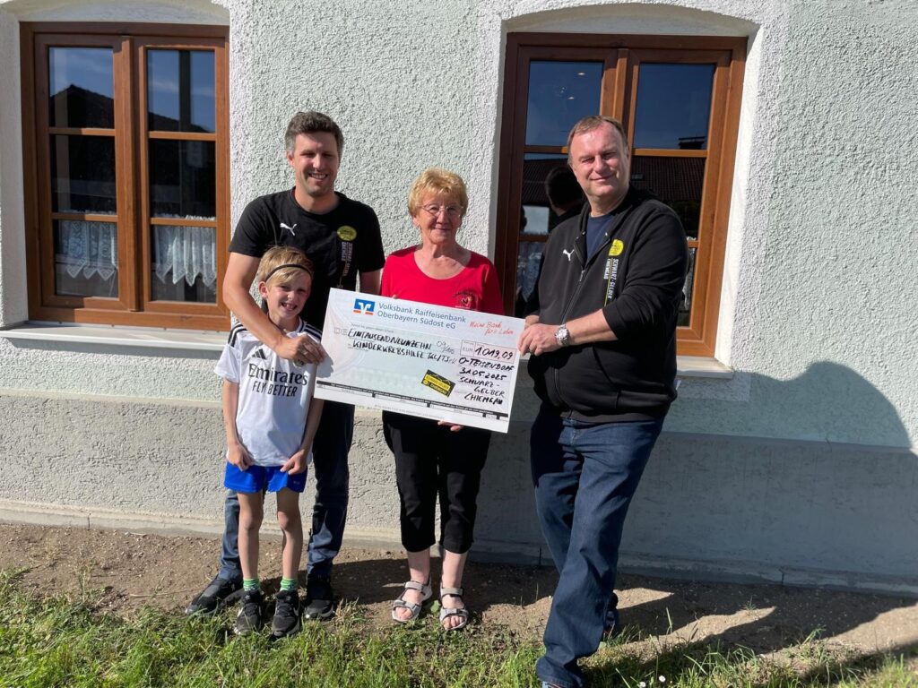 Spendenübergabe bei der Kinderkrebshilfe: Jakob und Elias Schnell sowie Christian Flamma überreichen den Spendenscheck an Rosmarie Baumgartner. Das Foto wurde vor dem Vereinsheim der Kinderkrebshilfe aufgenommen.