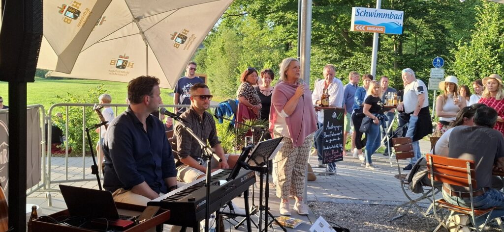 Auf der Bühne die beiden Musiker der Band Lautstaad sowie am Mikrofon Gitti Aicher, Kassiererin der Kinderkrebshilfe.
